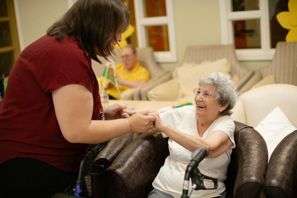 A caregiver helping an older woman walk with a walker